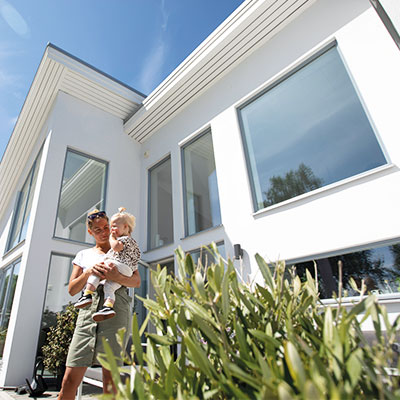 Mamma och barn framför sitt hus